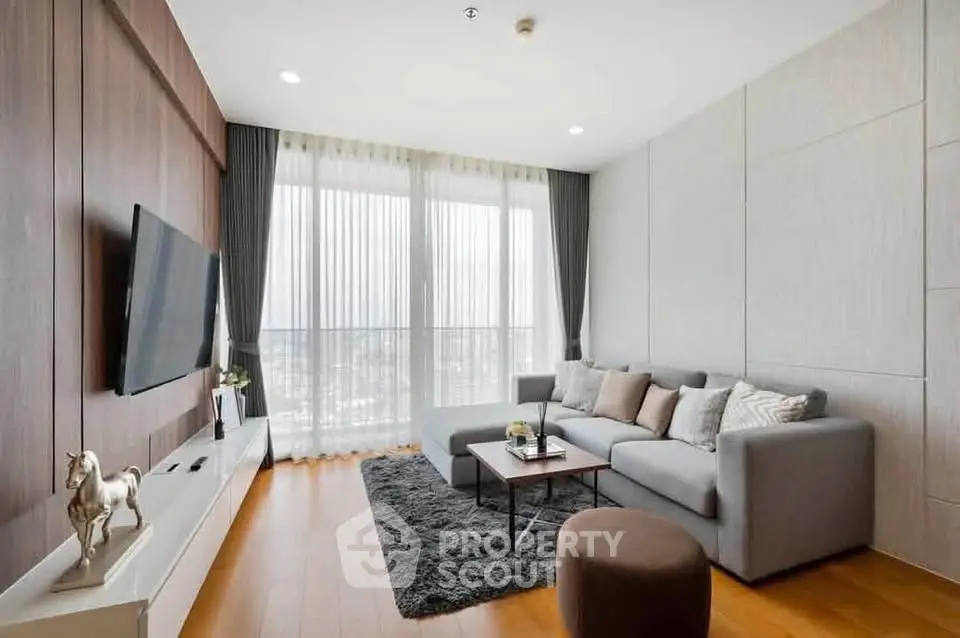 Modern living room with sleek design, large windows, and cozy seating area.