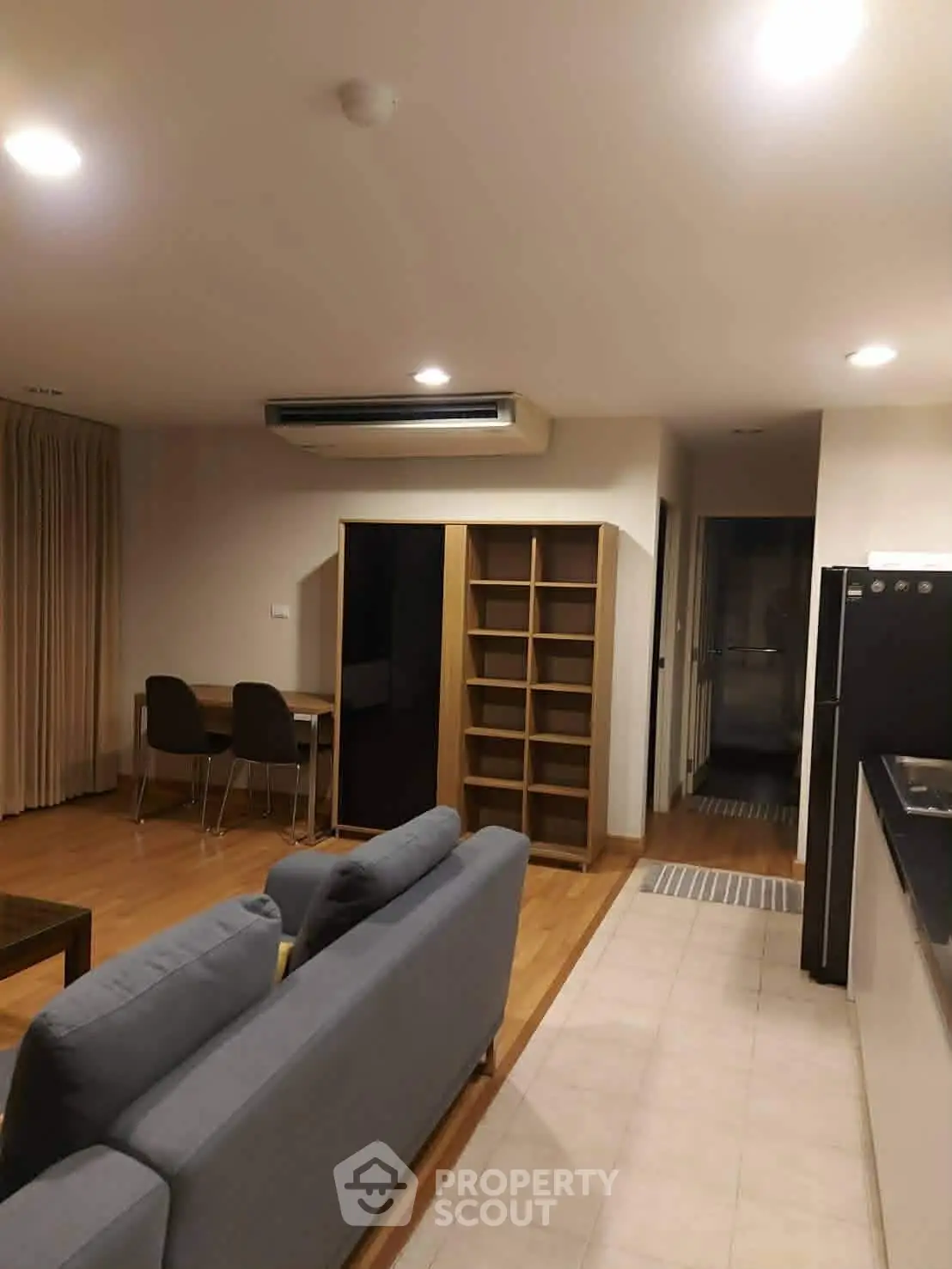 Modern living room with cozy seating and dining area in open layout apartment.