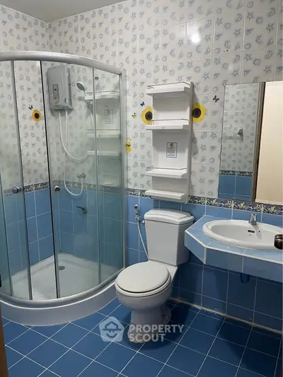 Charming bathroom with blue tile decor and modern shower enclosure.