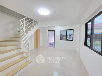 Spacious modern living room with staircase and large windows in a bright home