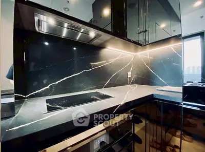 Luxurious modern kitchen with sleek black marble countertops and built-in oven, perfect for gourmet cooking.