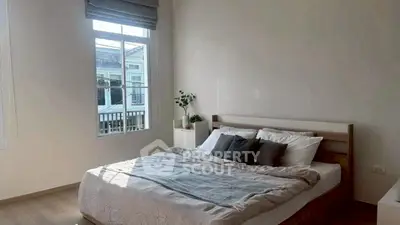 Bright and cozy bedroom with large window and modern decor