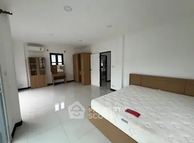 Spacious bedroom with modern furnishings and ample natural light, perfect for comfortable living.