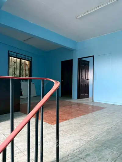 Spacious interior with unique staircase and vibrant blue walls, ideal for creative living space.