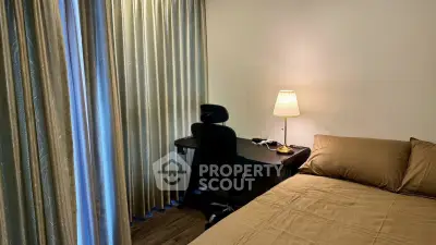 Cozy bedroom with study desk and elegant curtains, perfect for a serene work-from-home setup.