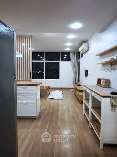 Modern open-plan living room with wooden flooring and minimalist decor.