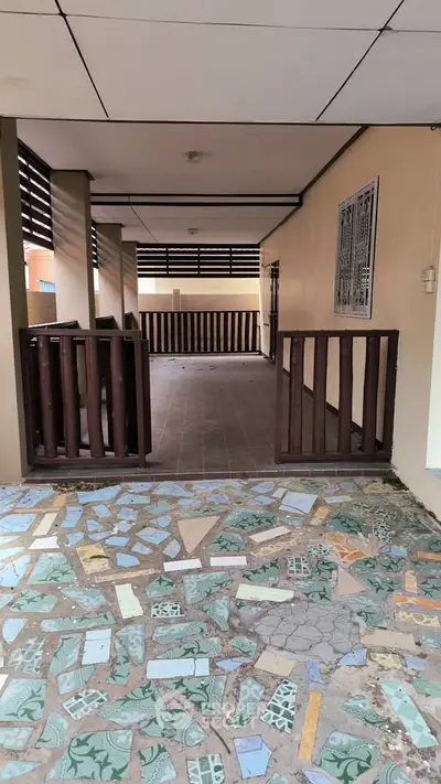 Spacious covered patio with decorative tile flooring and wooden railings, perfect for outdoor relaxation.