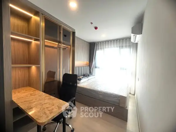 Modern bedroom with study desk and large window, perfect for comfort and productivity.