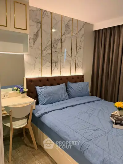 Modern bedroom with elegant marble accent wall and cozy blue bedding