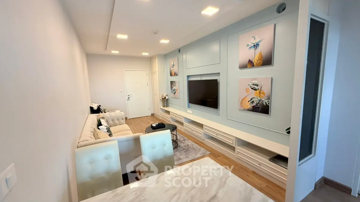 Modern living room with elegant decor and cozy seating area, featuring stylish wall art and a sleek entertainment unit.