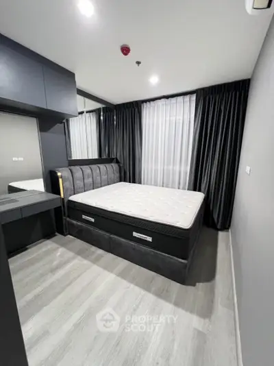 Modern bedroom with sleek design, featuring a comfortable bed and stylish decor in a contemporary apartment.