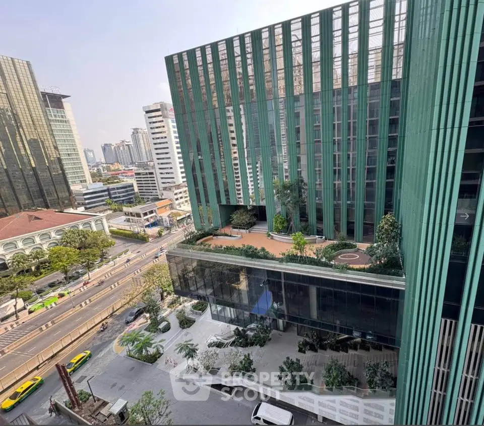 Stunning modern building with green facade and rooftop garden in urban setting.