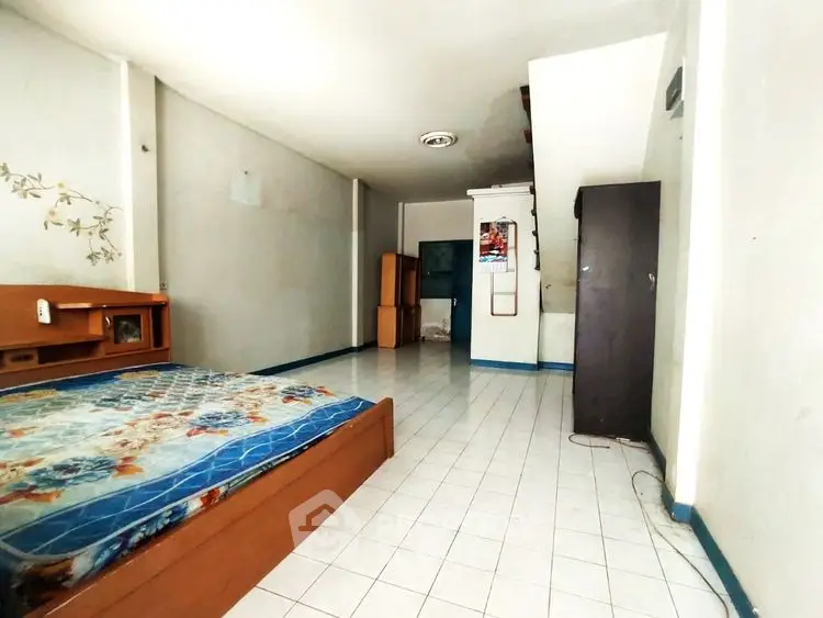 Spacious bedroom with tiled flooring and minimal furnishings