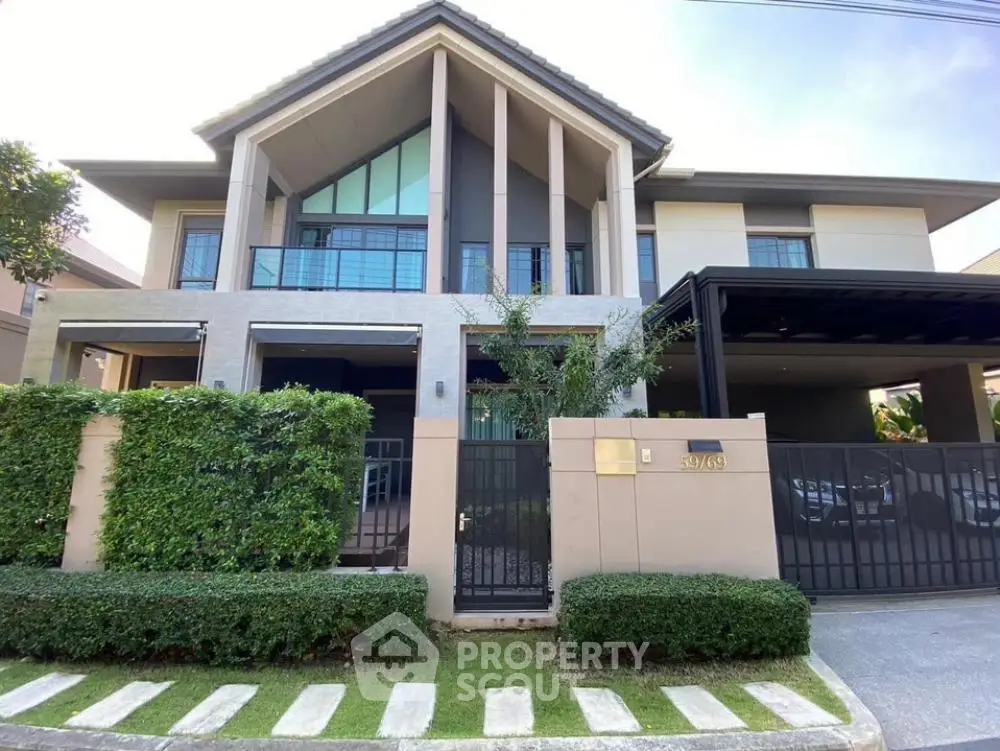 Stunning modern two-story house with large windows and lush greenery, perfect for luxurious living.