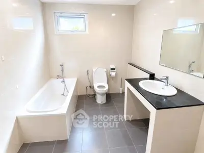 Spacious modern bathroom with bathtub and sleek fixtures