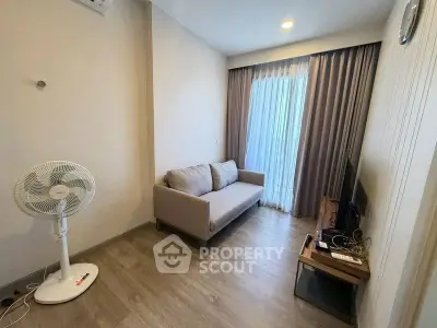 Cozy living room with modern decor and natural light, featuring a comfortable sofa and entertainment setup.