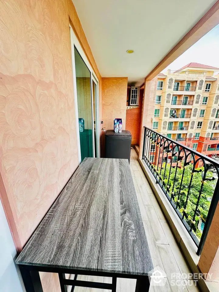 Charming balcony with stylish table and scenic view of vibrant residential buildings.