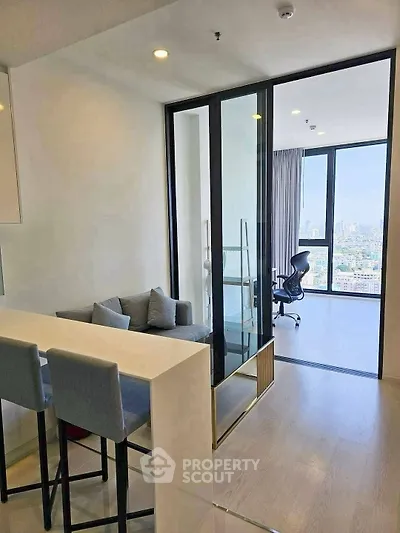 Modern apartment with open layout, featuring a cozy living area and a stunning city view from the balcony.