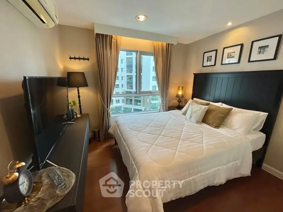 Cozy bedroom with modern decor and large window offering city view