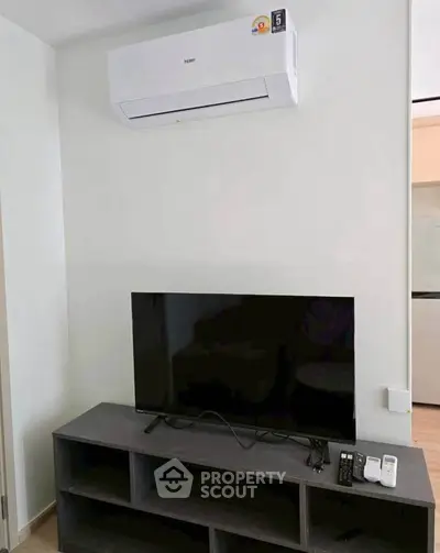 Modern living room with air conditioner and flat-screen TV on sleek stand.