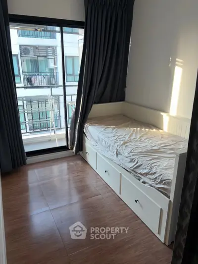 Cozy bedroom with large window and built-in storage bed in modern apartment.