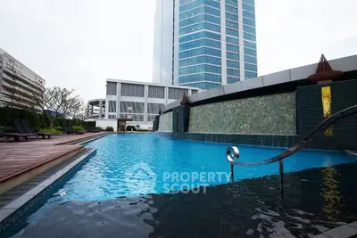 Luxurious rooftop pool with stunning cityscape views in modern high-rise building.