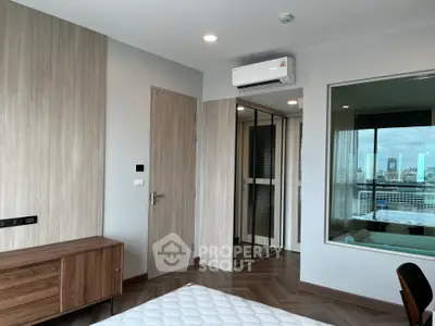 Modern bedroom with city view, featuring sleek wood finishes and air conditioning.