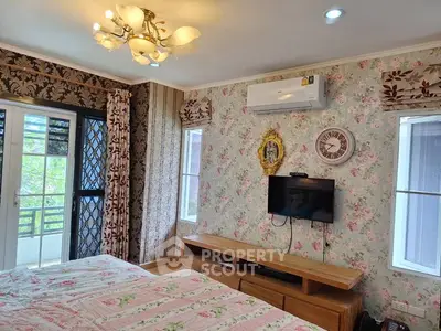 Charming bedroom with floral wallpaper and balcony access