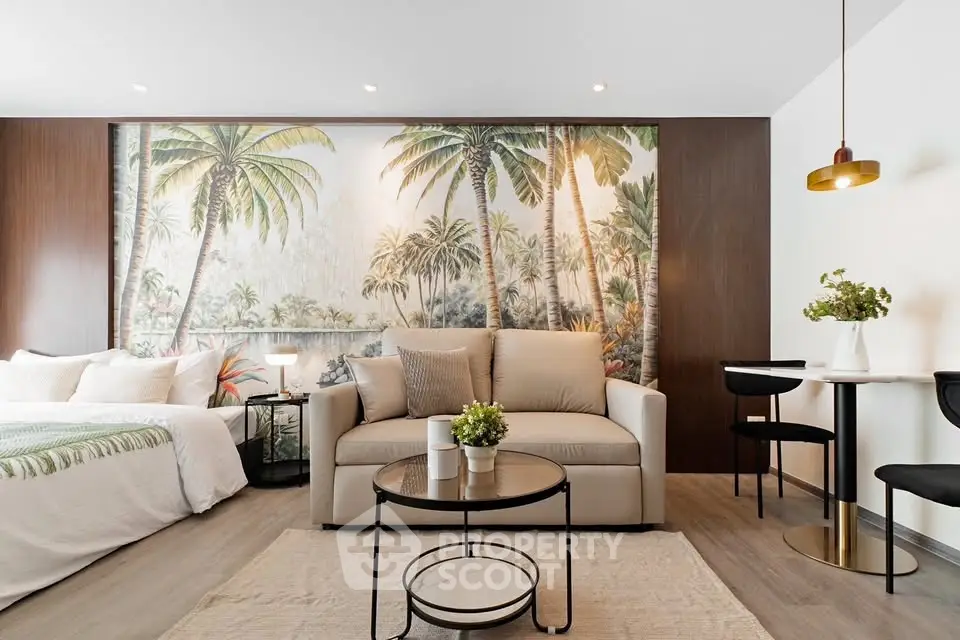 Chic studio apartment with tropical-themed decor, featuring a cozy living area and modern furnishings.