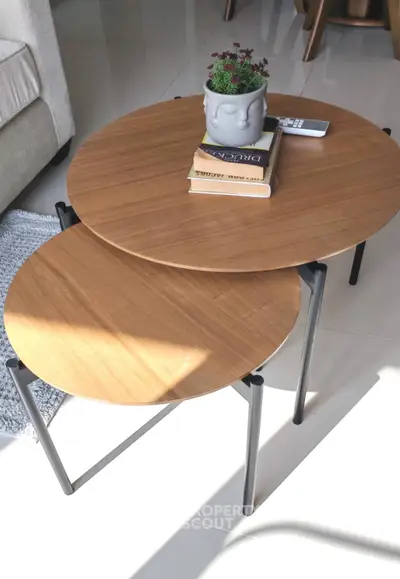 Modern living room with stylish nested coffee tables and cozy decor.