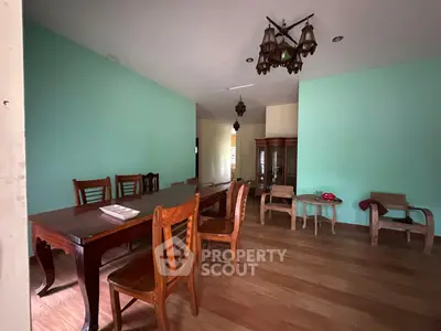 Spacious dining area with wooden furniture and elegant chandelier