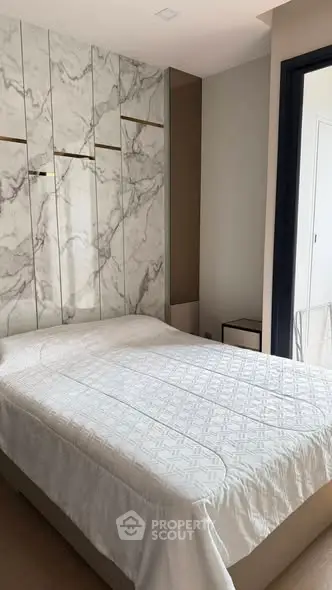 Modern bedroom with elegant marble accent wall and cozy bed setup