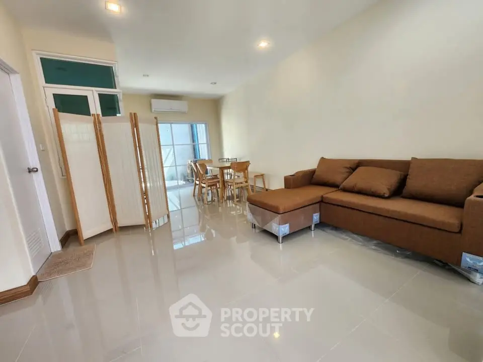 Spacious living room with modern furniture and dining area, perfect for relaxation and entertainment.