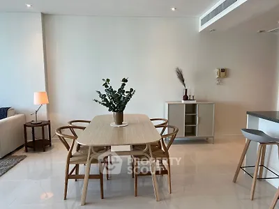 Modern dining area with stylish wooden table and chairs in a bright open-plan living space.