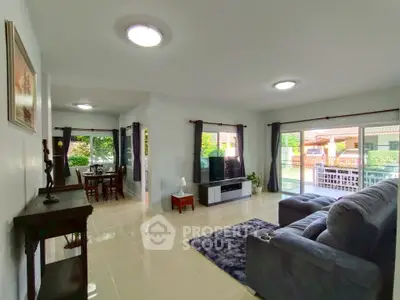 Spacious living room with modern decor and large windows offering garden views.