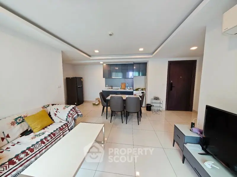 Modern open-layout living room with stylish kitchen and dining area.