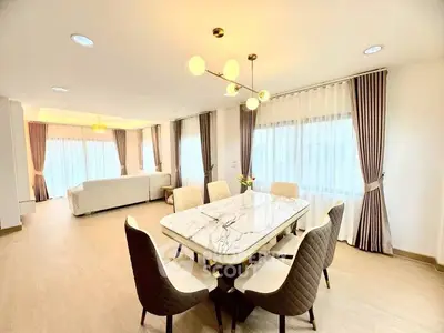 Spacious modern dining area with elegant marble table and stylish lighting