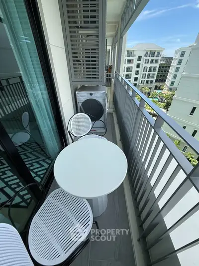 Charming balcony with modern furniture and scenic view in a contemporary apartment complex.