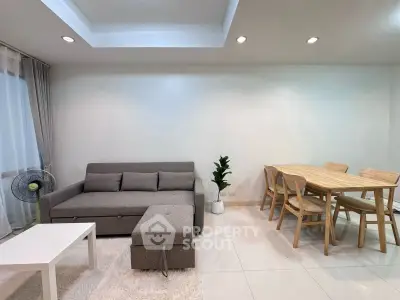 Modern living room with cozy sofa, dining set, and stylish decor in a bright open space.