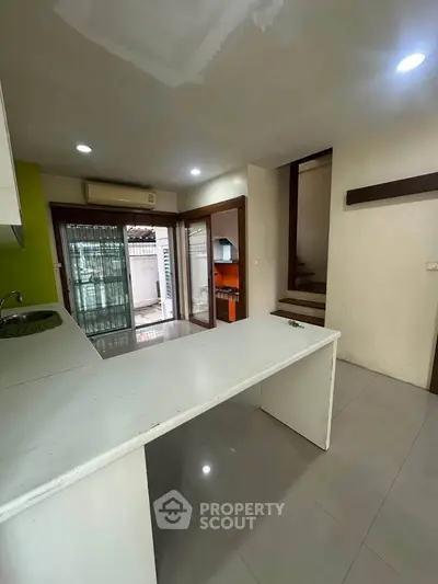 Spacious kitchen with open layout and modern design, featuring a sleek countertop and ample natural light.