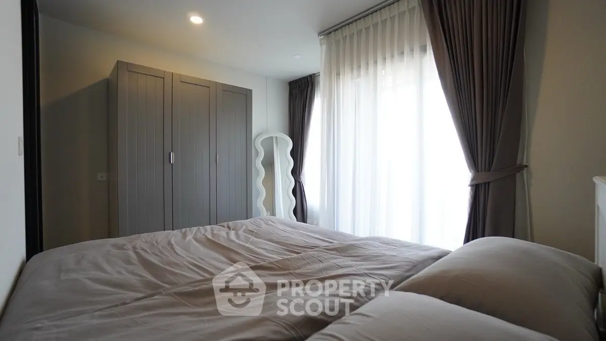 Cozy bedroom with elegant curtains and modern wardrobe