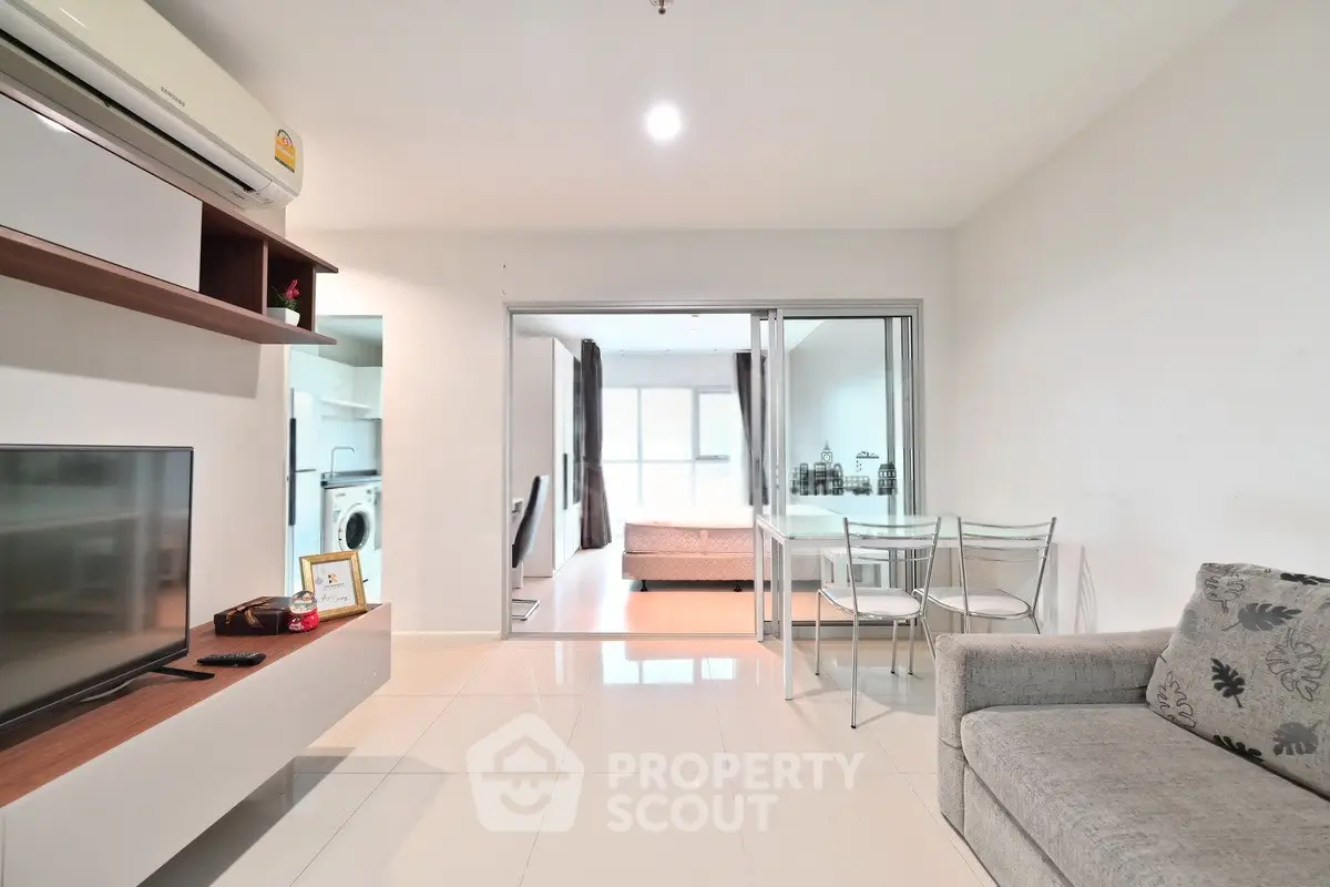 Modern living room with sleek furniture and open layout, featuring a cozy dining area and bright natural light.
