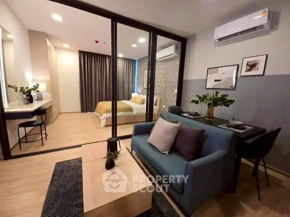 Modern living room with stylish decor and open view to cozy bedroom, featuring sleek furniture and ambient lighting.