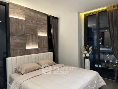 Modern bedroom with stylish lighting and large windows offering city views.