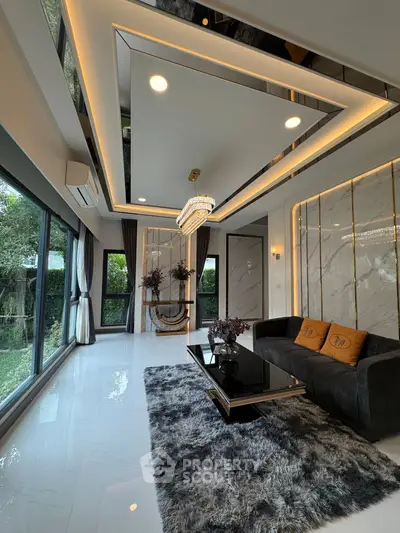 Luxurious modern living room with elegant chandelier and large windows overlooking garden.