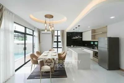 Luxurious modern kitchen with open layout and elegant dining area, featuring sleek appliances and stylish lighting.