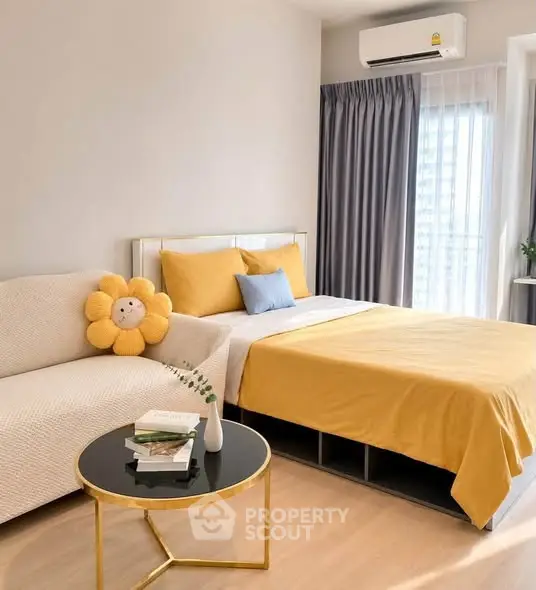 Modern bedroom with cozy decor, featuring a stylish bed, sofa, and air conditioning.