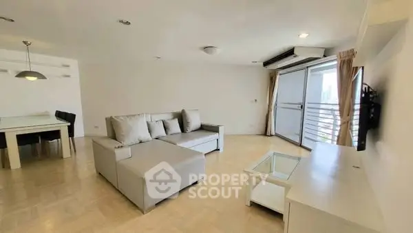 Spacious living room with modern furniture and balcony access