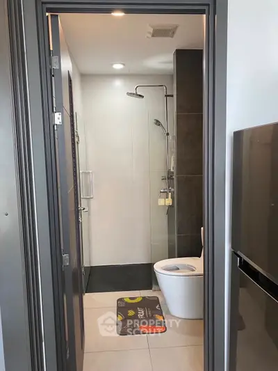 Modern bathroom with sleek shower and toilet in compact space.