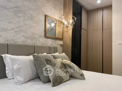 Luxurious bedroom with modern decor and elegant lighting, featuring a stylish wardrobe and plush pillows.